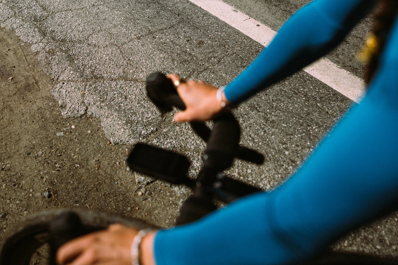 A rider's-eye view from the cockpit of an ALLIED ECHO road bike, hands on the drops over rough road.